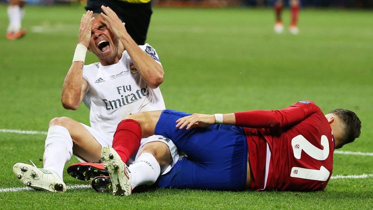 Real Madrid-speler Pepe (links) en Yannick Carrasco van Atlético Madrid liggen op de grond. Beeld epa