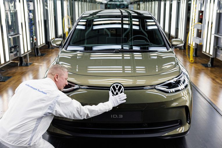 Een VW-werknemer legt de laatste hand aan een exemplaar van de elektrische Volkswagen ID 3.  Beeld AFP