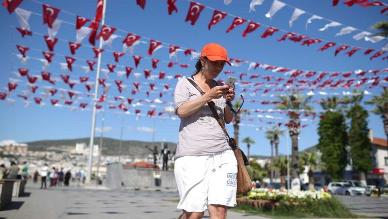 Metro-columniste Ebru Umar voert een telefoongesprek op de boulevard langs het strand van Kusadasi, de dag na haar vrijlating. Beeld ANP