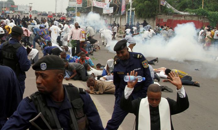 Oproerpolitie zet traangas in om katholieke priesters en demonstranten uiteen te drijven tijdens een door de katholieke kerk in Kinshasa georganiseerde protestactie tegen president Kabila.