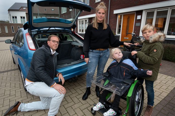 Mano en Sandra de Graaf met hun twee zonen Joep en Bram voor de personenauto die te klein is geworden voor de rolstoel van Joep. Bram zit vaak met twee rolstoelwielen op zijn schoot, omdat niet alles in de achterbak past.