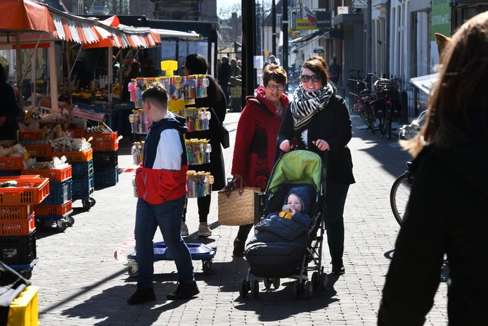 Met melkbussen, afzetlinten en kratten (links) worden de klanten op de markt in Vianen keurig op 1,5 meter van elkaar gehouden.