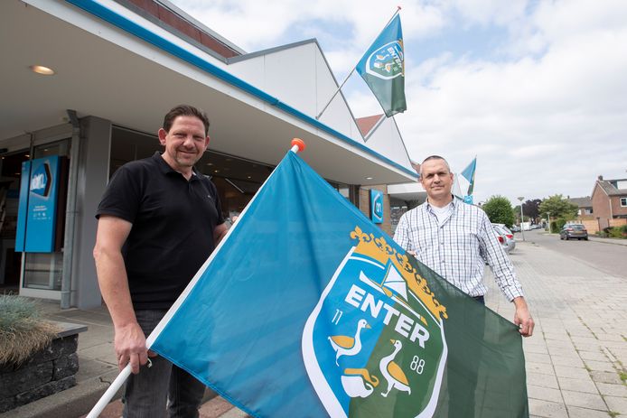 Initiatiefnemers Eric Tijhof (links) en Patrick ten Hove achter een vlag met het Enterse dorps wapen.