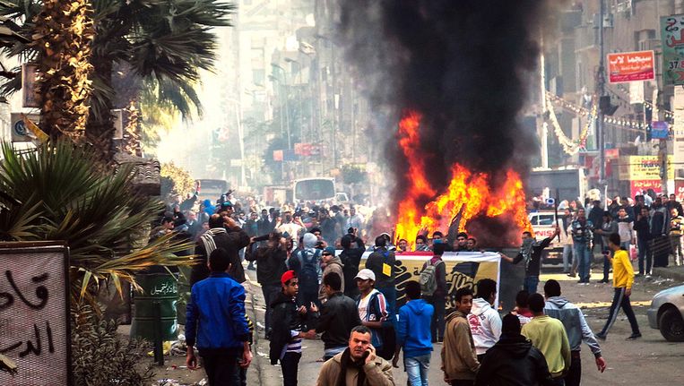 Egyptische demonstranten steken een politieauto in brand tijdens de anti-coup-protesten in Gizeh vandaag Beeld getty