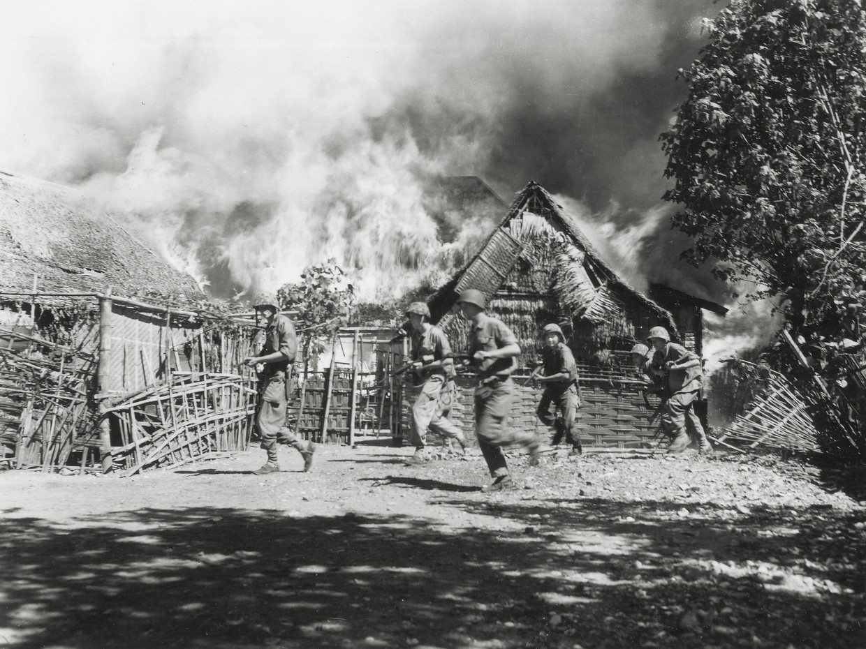 Nederlandse militairen op een brandende kampong op Oost-Java in 1946. Beeld Hugo A. Wilmar / Koninklijke Marine