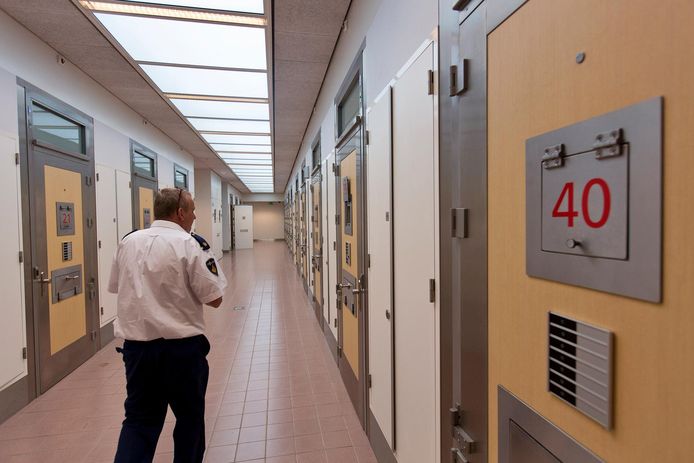 Een agent loopt langs cellen op het politiebureau van Apeldoorn.