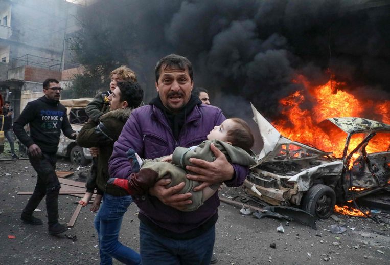 Eind januari van dit jaar. Kinderen worden weggedragen na een explosie in de stad Azaz, in een door rebellen gecontroleerd gebied in de provincie Aleppo. Beeld AFP