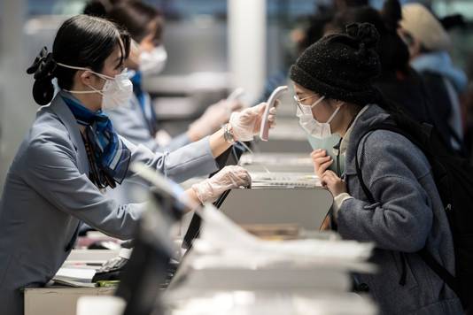 Een passagier wordt onderworpen aan een temperatuurcheck voor het nemen van een vlucht op een luchthaven in Tokio, Japan. 