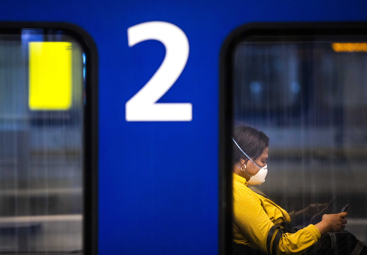 Een reiziger met een mondkapje op station Den Haag Centraal. 