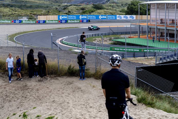 Racefans proberen in de duinen een glimp op de vangen van de komst van de Formule 1-karavaan.