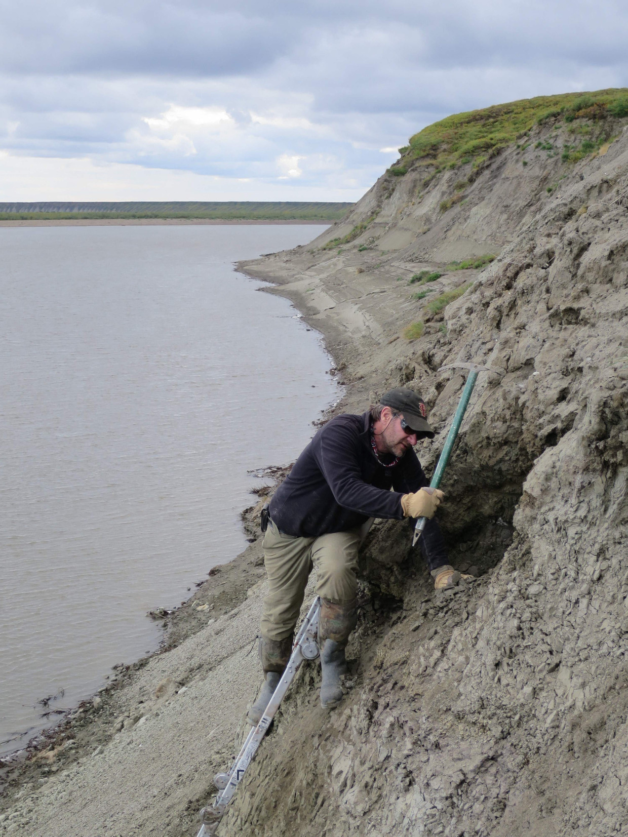Researcher Greg Erickson bezig met opgravingen aan de oevers van de Colville River in Noord Alaska. Dinosaurussen kwamen hier niet alleen maar langs, ze leefden er permanent – ondanks de barre omstandigheden.  Beeld AFP