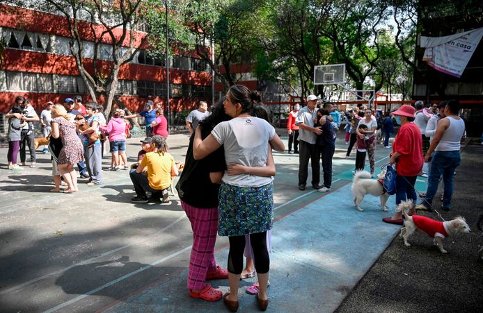 Mensen omarmen elkaar na de aardbeving in Mexico-stad. Mensen staan buiten uit angst voor naschokken of instortende gebouwen.