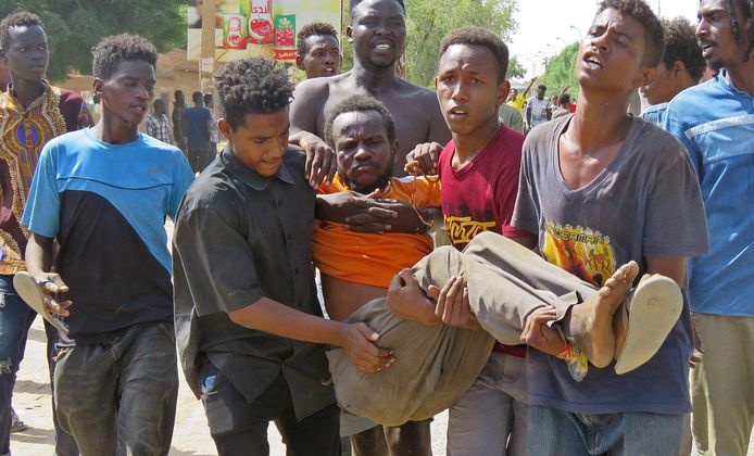 Een gewonde man wordt weggedragen tijdens protesten in Omdurman.
