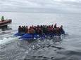 Bootje met 38 transmigranten onderschept voor kust Koksijde. Gekregen van politie. Mens op boot die ernaast te zien is, is van de Belgen die hen voor de veiligheid begeleidden - omdat ze niet wilden terugkeren