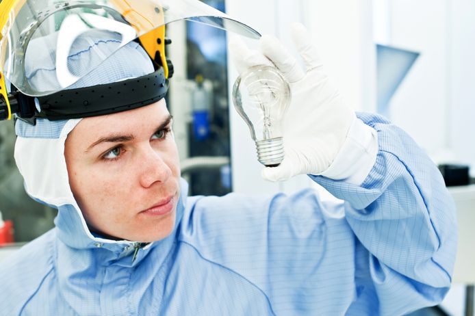 Een ingenieur onderzoekt verlichting in een laboratorium in het kader van kwaliteitscontrole.
