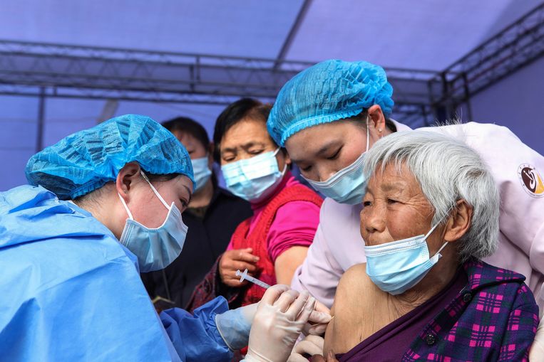 Een Chinese vrouw krijgt een prik tegen corona in Chongqing, een stad in het westen van China. 
 Beeld ANP / AFP
