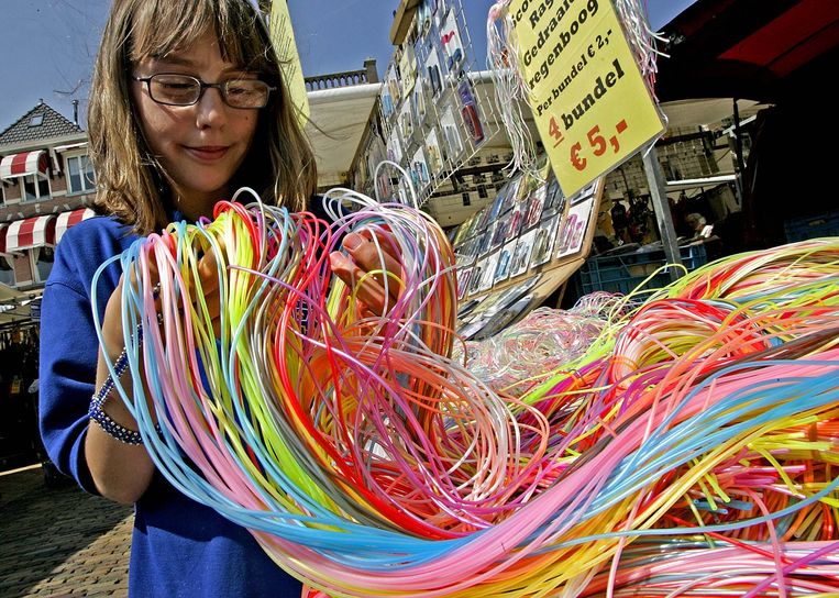Een meisje op de markt in Delft bekijkt donderdagmiddag strengen scoubidou-touwtjes. Het populaire speelgoed blijkt giftige weekmakers te bevatten.  Beeld ANP