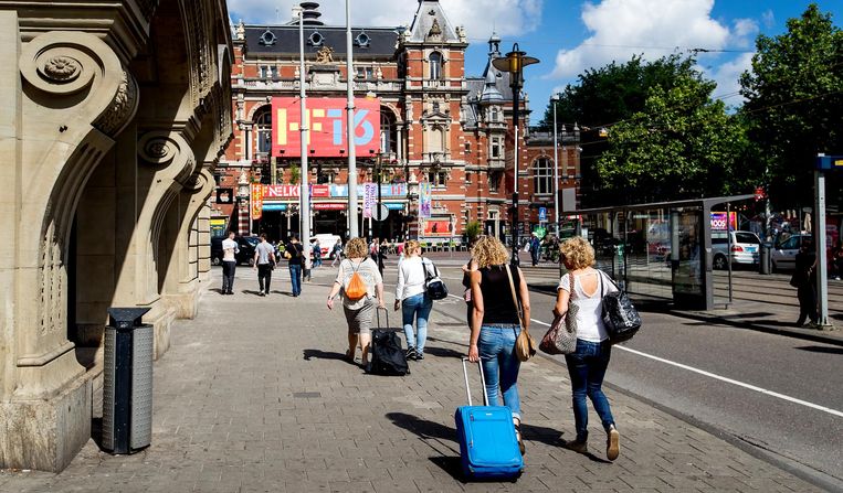 Toeristen met rolkoffers op het Leidseplein in Amsterdam. Beeld anp