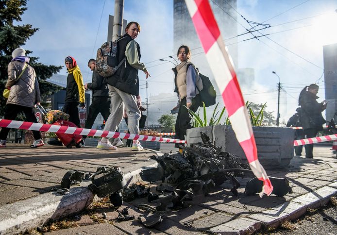 Voorbijgangers kijken naar de restanten van een in Kiev geëxplodeerde kamikazedrone, vermoedelijk een van Iraanse makelij.