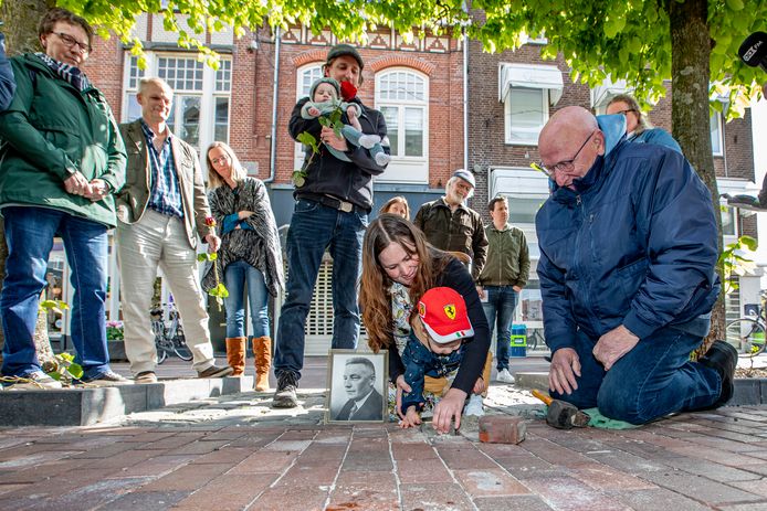Luca Gombert plaatst, geholpen door familieleden, de Stolperstein voor zijn overleden betovergrootvader in de Grotestraat.