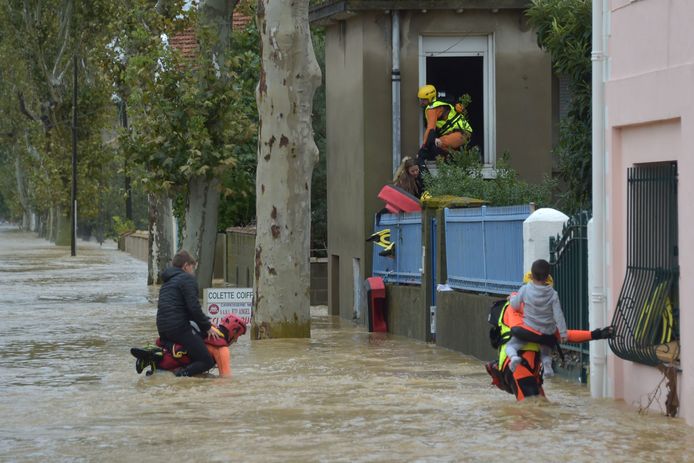 Brandweermannen helpen kinderen evacueren uit hun huizen in Trèbes.
