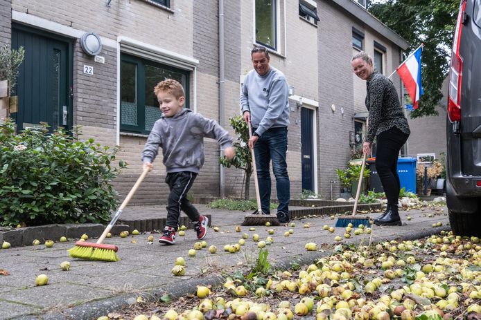 Saskia de Kok veegt samen met haar buurman en zoontje Dave de peren uit haar straat.