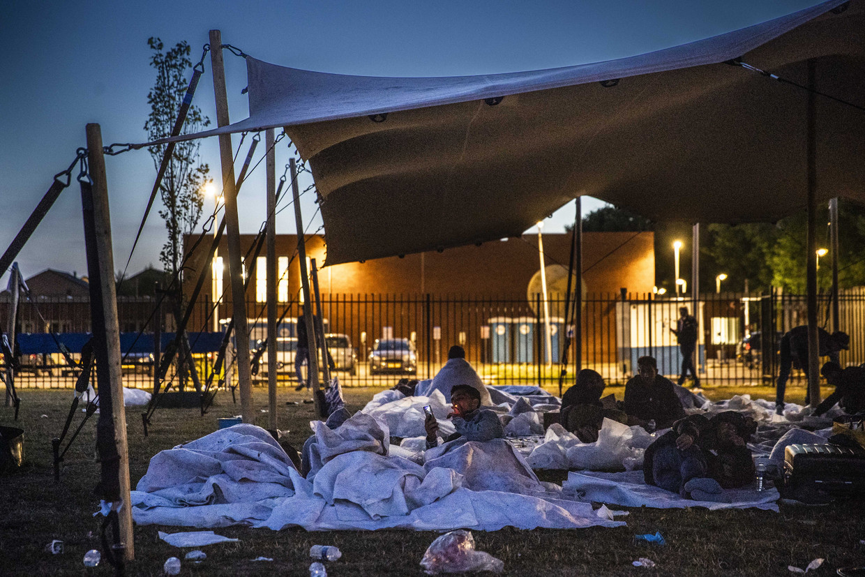 Asielzoekers bij het aanmeldcentrum in Ter Apel maken zich op voor de nacht in de buitenlucht.  Beeld Vincent Jannink/ANP