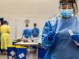 Een medewerker van de GGD Amsterdam neemt een coronatest af in een testlocatie bij de RAI.