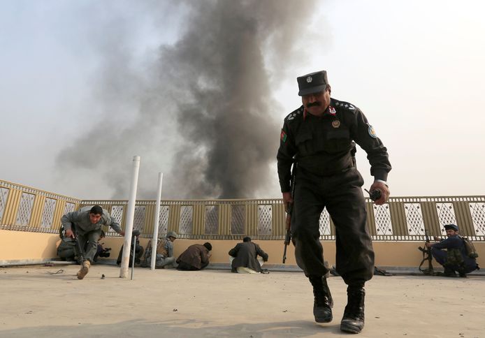 Afghaanse politie-agenten zoeken dekking na de aanval op het kantoor van Save The Children.