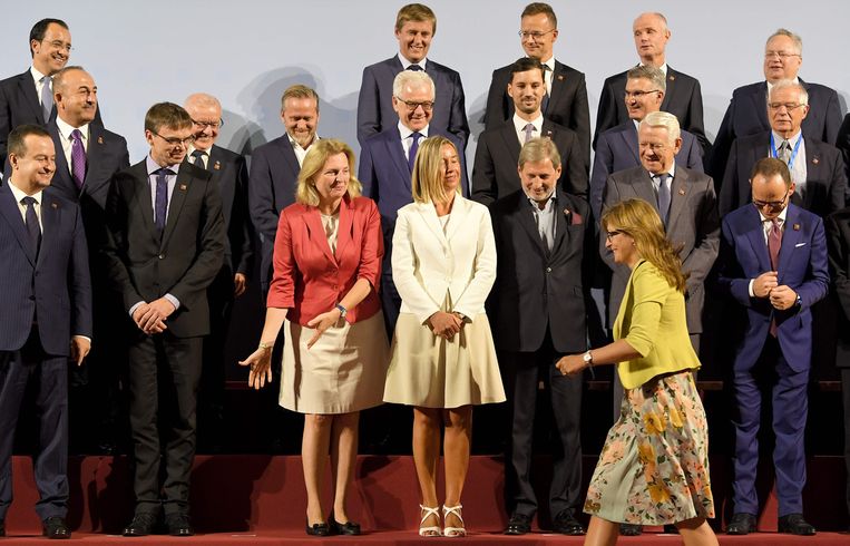 Gastvrouw Karin Kneissl, in het oranje jasje, ontvangt haar Europese collega-ministers van Buitenlandse Zaken in Wenen. Beeld Roland Schlager / AFP