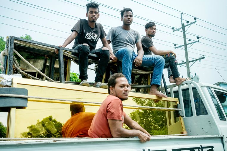 Jonge arbeiders achter op de vrachtwagen in Dhaka. Zij hebben de keuze in Bangladesh te blijven of om als arbeidsmigrant naar het Midden-Oosten te gaan. Beeld Patrick Post