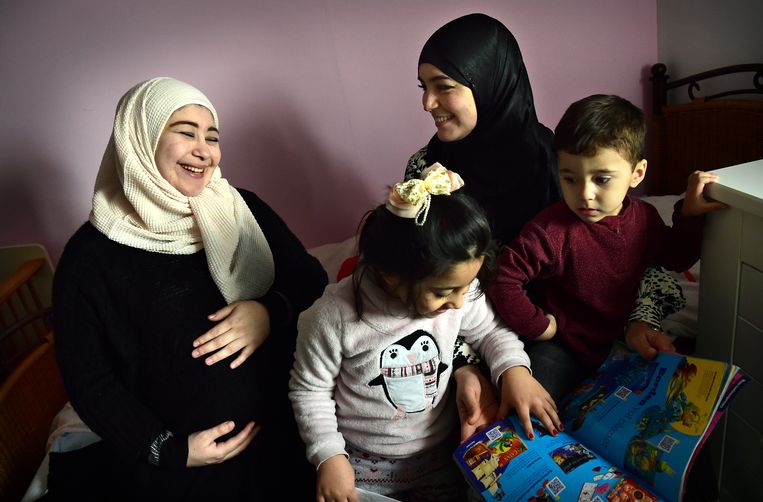 De zwangere Hiba Alshafi (l), haar twee kinderen, en haar 'ma-maatje’ Aasma el Fahmi (r). Beeld Marcel van den Bergh