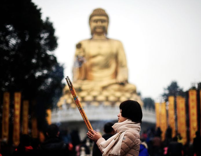 Een Chinese boeddhiste bidt tijdens een bezoek aan de Huayantempel in Chongqing