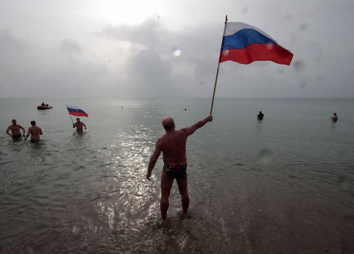 Een man op de Krim draagt trots de Russische vlag.