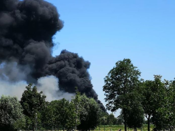 Zwarte rookwolken van de brand zijn te zien vanaf het Weidepad in Linschoten.