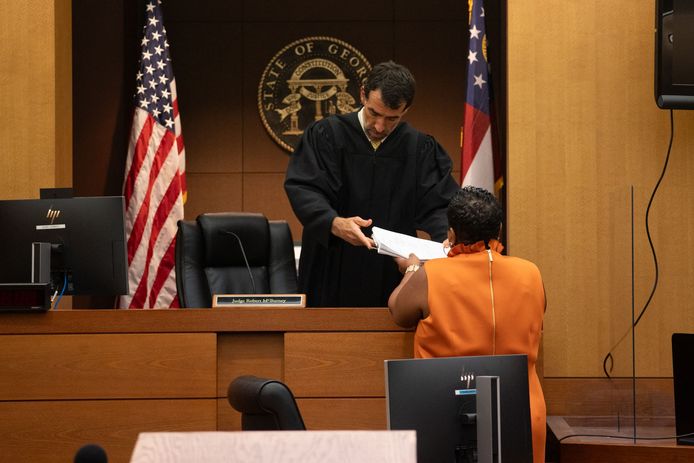 Klerk Che Alexander overhandigt de documenten aan rechter Robert McBurney van de rechtbank van Fulton County.