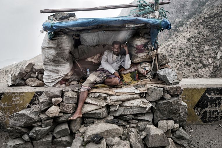Een strijder staat op de wacht naast de weg naar Aden.  Beeld Olivier Laban-Mattei / MYOP