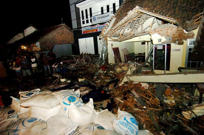 Indonesiërs zoeken in het puin van een huis naar overlevenden nadat een vrachtwagen moest uitwijken en inreed op het huis.