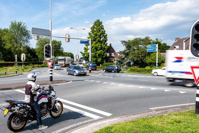Een motorrijder wacht voor het rode licht op de N201.