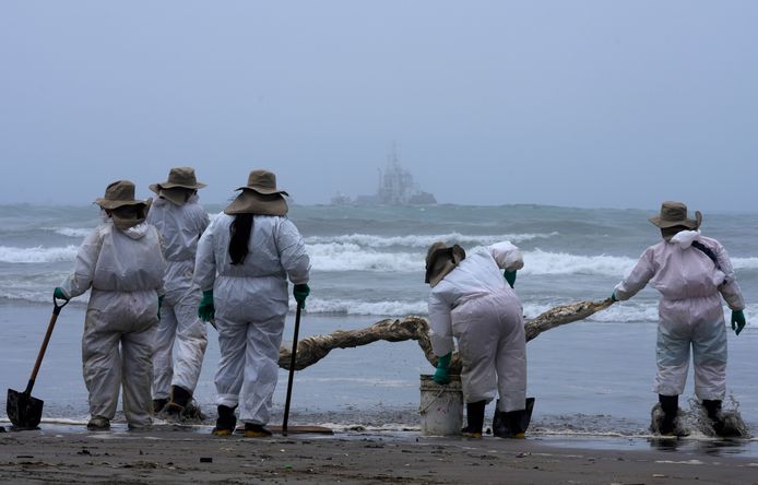 Workers continue in a clean-up campaign after an oil spill, on Cavero Beach in the Ventanilla district of Callao, Peru, Saturday, Jan. 22, 2022. The oil spill on the Peruvian coast was caused by the waves from an eruption of an undersea volcano in the South Pacific nation of Tonga. (AP Photo/Martin Mejia)