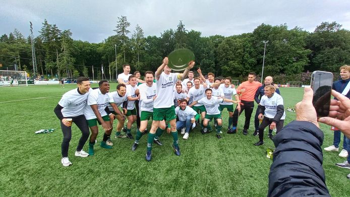 RPC viert het kampioenschap in de derde klasse D. Aanvoerder Joris van der Steen toont de kampioensschaal.