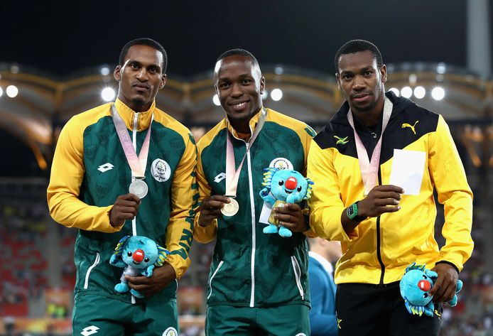 Het podium in Gold Coast met de Zuid-Afrikaan Henricho Bruintjies met het zilver, zijn landgenoot Akani Simbine met het goud en het brons oor Yohan Blake.