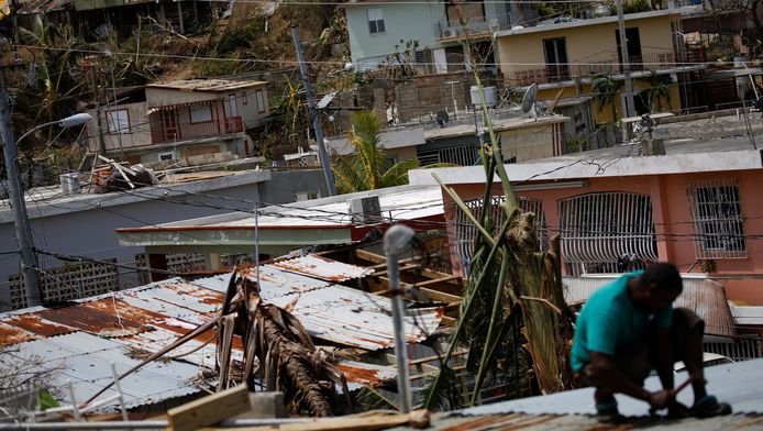 Een man probeert zijn huis te repareren nadat het getroffen werd door orkaan Maria.