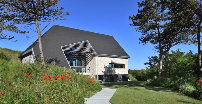 De duinwoning bij Domburg. De oostzijde is opgetrokken met Scandinavische steen, het dak is van leisteen. De in het dak uitgespaarde hoek is voorzien van balken die voor uitzicht en zonwering zorgen.