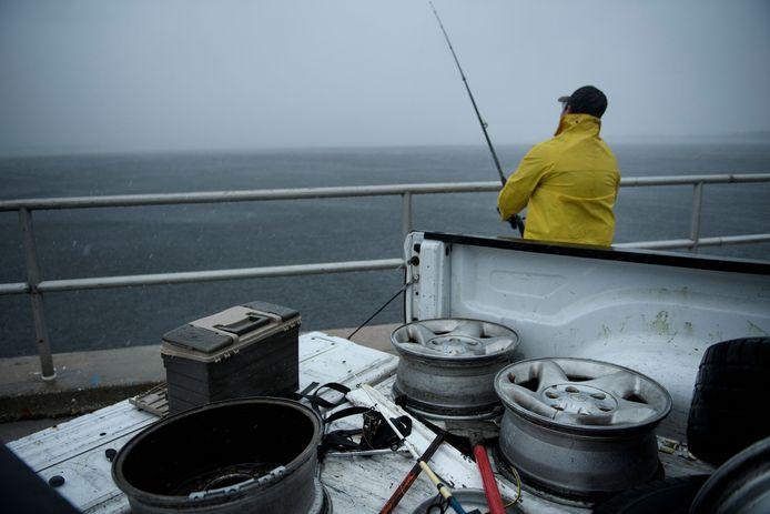 Een visser slaat zijn laatste vangst aan de haak voordat orkaan Michael aan land komt.
