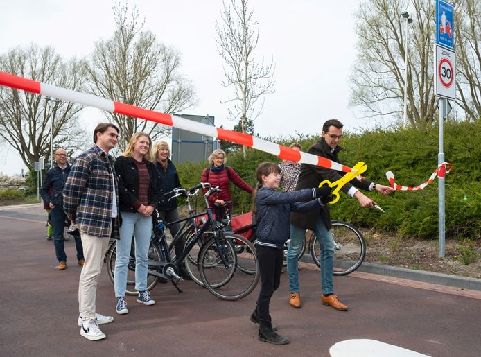 Wethouder Ashley North (rechts) samen met de 9-jarige bewoner Iris Meijer (midden) openen samen de nieuwe fietsstraat.
