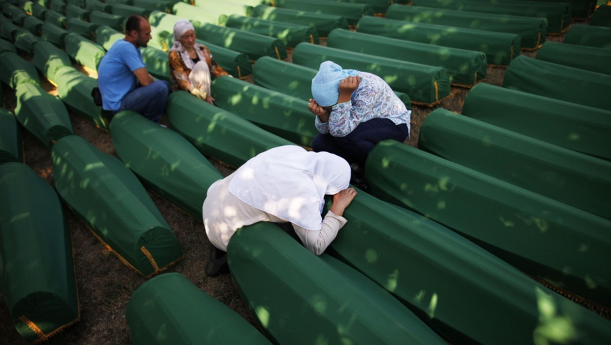 Bosnische vrouwen huilen naast de kisten van familieleden. In Srebrenica worden vandaag 520 onlangs geïdentificeerde lichamen herbegraven. Beeld reuters