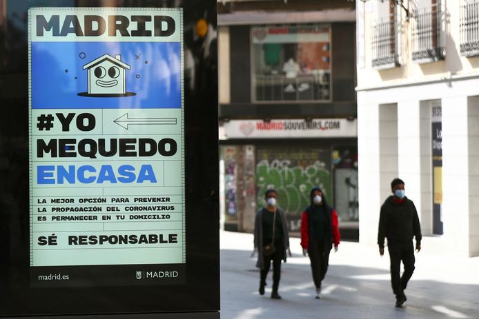 Een poster met de tekst "Ik blijf thuis" en "wees verantwoordelijk" in het straatbeeld in Madrid.