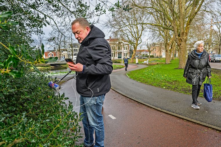 Zwerfinator Dirk Groot plukt met een grijper een blikje uit een struik. Beeld Guus Dubbelman / de Volkskrant