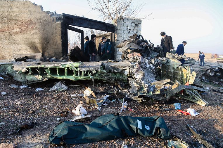 Hulpverleners bij de brokstukken van het neergestorte Oekraïense vliegtuig. Beeld AFP